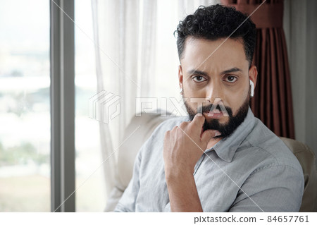 Frowning Man Listening to Podcast or Audiobook Frowning Man Listening to Podcast or Audiobook 84657761