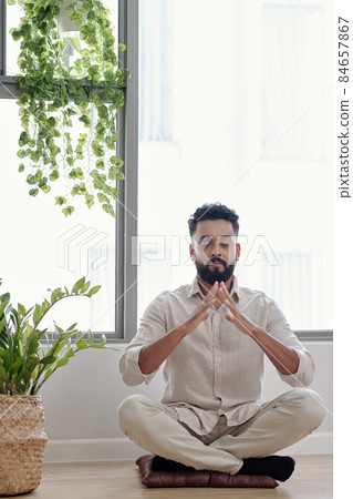 Relaxed Man Meditating at Home 84657867