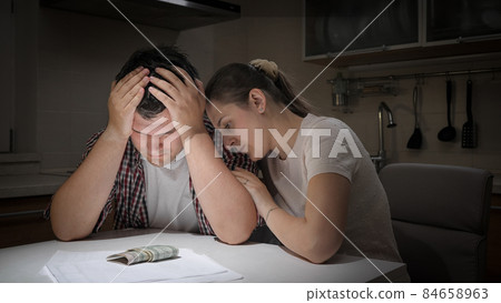 Young loving wife comforting and consoling her husband having financial problems and difficulties Young loving wife comforting and consoling her husband having financial problems and difficulties 84658963