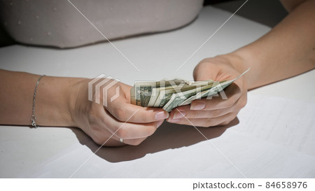 Closeup of porr woman counting few banknotes she has left Closeup of porr woman counting few banknotes she has left 84658976