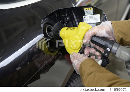 A person who refuels a car A person who refuels a car 84659071