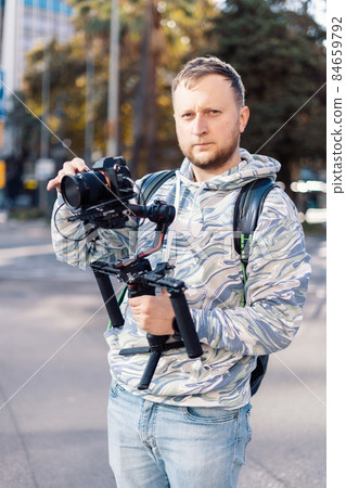 Professional videographer with gimball equipment setup before shooting. He is ready for video work 84659792