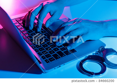 Cyber crime concept with man in handcuffs Cyber crime concept with man in handcuffs 84660200