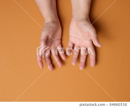 two female hands on a brown background. Empty palms open, top view 84660538