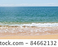 Turquoise sea waves splashing on sand shore 84662132
