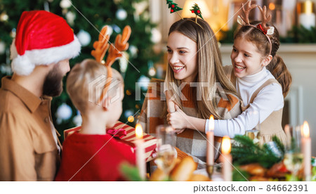 Happy family with two children celebrate Christmas at home, parents and kids exchanging xmas gifts 84662391
