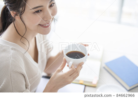 A woman taking a break while studying or working from home A woman taking a break while studying or working from home 84662966
