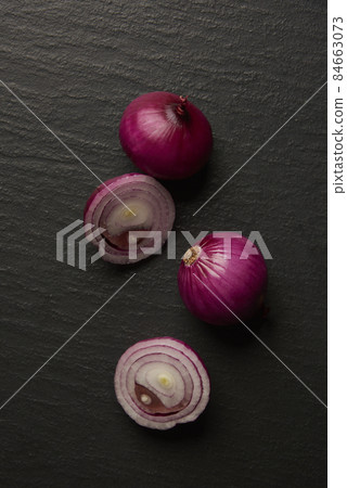 vegetable concept a few half-cut onions being put on the dark background vegetable concept a few half-cut onions being put on the dark background 84663073