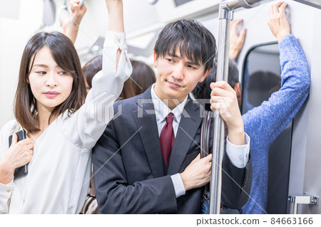在擁擠的火車上通勤的商務人士 在擁擠的火車上通勤的商務人士 84663166