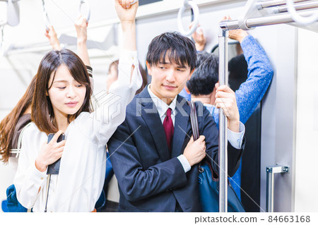 Business person commuting on a crowded train 84663168