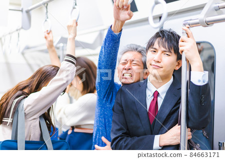 Business person commuting on a crowded train Business person commuting on a crowded train 84663171