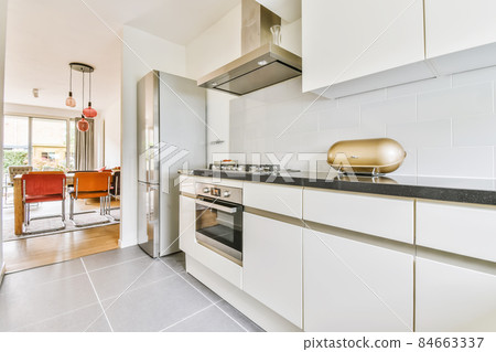 Adorable kitchen area with modern oven and refrigerator Adorable kitchen area with modern oven and refrigerator 84663337