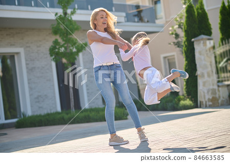 Young woman and a girl having fun in the street 84663585