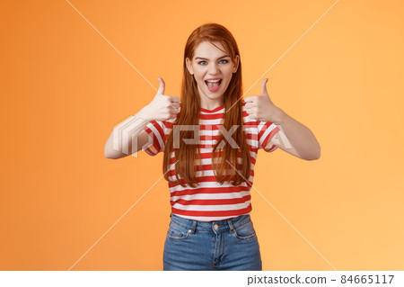 Sassy rebellious wild redhead cool girl having fun adore awesome party, show satisfactory gesture, thumb-up smiling say yeah joyfully, enjoy cool event, having fun, like idea, orange background Sassy rebellious wild redhead cool girl having fun adore awesome party, show satisfactory gesture, thumb-up smiling say yeah joyfully, enjoy cool event, having fun, like idea, orange background 84665117