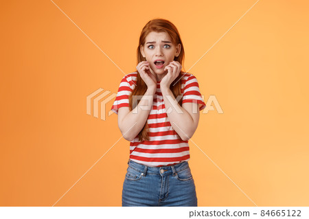 Innocent scared redhead female victim feel afraid standing stupor trembling fear, drop jaw gasping shocked, stare terrified, speechless look camera, frightened stand orange background Innocent scared redhead female victim feel afraid standing stupor trembling fear, drop jaw gasping shocked, stare terrified, speechless look camera, frightened stand orange background 84665122