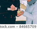 guy pour hot coffee to his girlfriend in green cup. winter hike theme 84665709