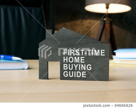 Dark model of home with sign first-time home buying guide. Dark model of home with sign first-time home buying guide. 84666826