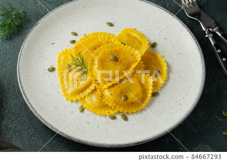 Homemade Pumpkin Ravioli with butter on a dark concrete background. Top view 84667293