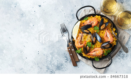 Traditional spanish seafood paella in pan with chickpeas, shrimps, mussels, squid on light grey concrete background. Top view with copy space Traditional spanish seafood paella in pan with chickpeas, shrimps, mussels, squid on light grey concrete background. Top view with copy space 84667318