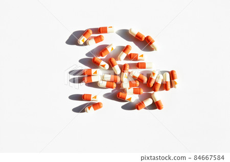 Orange and white capsule pills isolated on white background Orange and white capsule pills isolated on white background 84667584