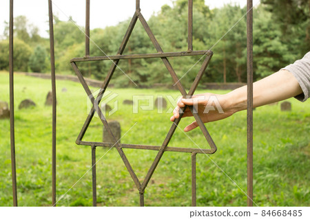 Star of David symbol and sign of the Jews on the iron grate of the old Jewish cemetery. Star of David symbol and sign of the Jews on the iron grate of the old Jewish cemetery. 84668485