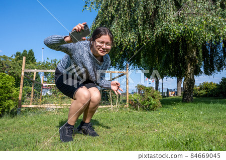 A twelve years old girl jumps in green grass A twelve years old girl jumps in green grass 84669045