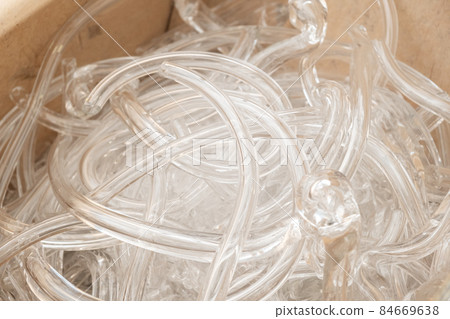 Broken clear glass pipes prepared for recycling and decorative items manufacturing in large wooden crate extreme close view Broken clear glass pipes prepared for recycling and decorative items manufacturing in large wooden crate extreme close view 84669638