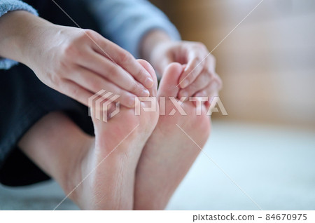 Cold young woman with cold feet 84670975