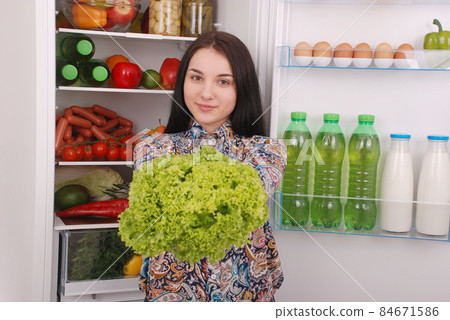 Beautiful young girl near the Fridge with healthy food. Beautiful young girl near the Fridge with healthy food. 84671586
