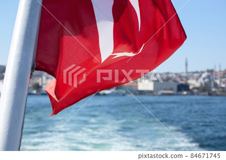 The national flag of Turkey against the Bosphorus waters and Istanbul city Buildings 84671745