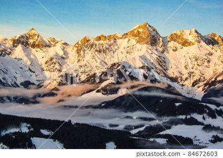 Sunrise in Maria Alm, Hinterthal in Austria. Winter landscape, stunning mountain range, snowy trees and blue sky 84672603