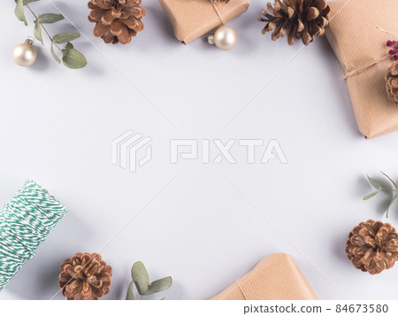 Christmas festive frame with wrapped presents, pine cones on gray 84673580