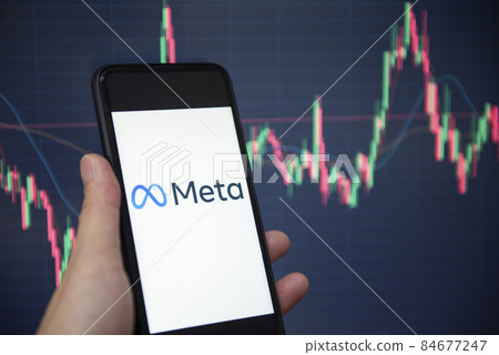 META logo on smartphone screen with hand hold and crypto currency or stocks graph charge trading screen on background. New facebook company logo meta metaverse. Bangkok Thailand, December 2, 2021 84677247