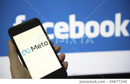 META logo on smartphone screen with hand hold and facebook logo on background screen. New facebook company logo meta metaverse concept. Bangkok Thailand, December 2, 2021 META logo on smartphone screen with hand hold and facebook logo on background screen. New facebook company logo meta metaverse concept. Bangkok Thailand, December 2, 2021 84677248