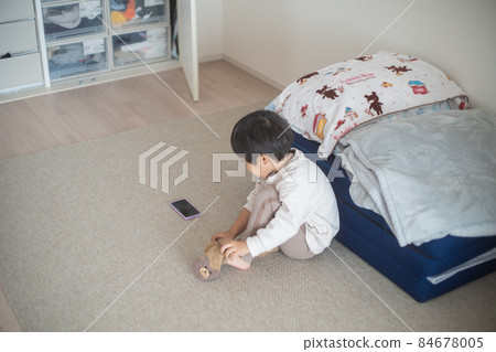 A 4-year-old child wearing socks while talking on a smartphone in a sunny room A 4-year-old child wearing socks while talking on a smartphone in a sunny room 84678005