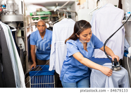 Daily laundry work - woman ironing clothes closeup Daily laundry work - woman ironing clothes closeup 84679133