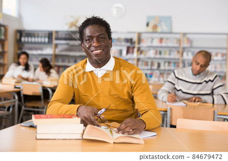 Young adult man studying in public library 84679472