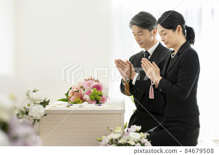 哀悼中的男女手持珠子在棺材前手牽手 哀悼中的男女手持珠子在棺材前手牽手 84679508