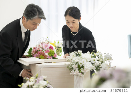 Middle-aged men and women looking inside the casket funeral image Middle-aged men and women looking inside the casket funeral image 84679511