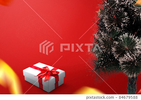 Decorated Christmas tree with a white gift box with a red ribbon 84679588