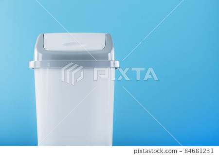 White trash can on a light blue background with free space. 84681231
