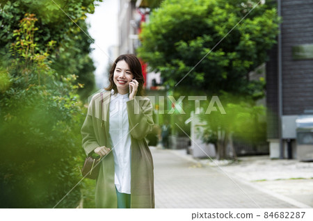 A young woman walking while making a phone call 84682287
