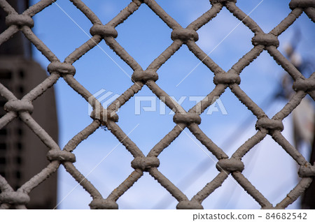 Closeup of vintage grille with shabby paint against blue sky 84682542