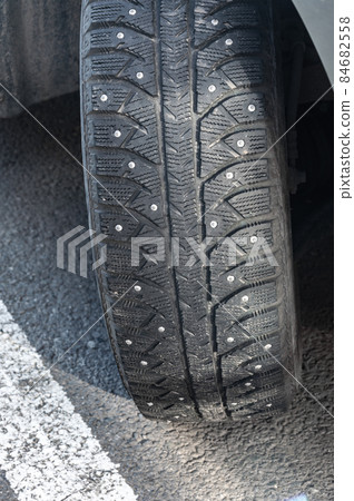 Studded car tire. Car tire with spikes. Winter tire. Studded car tire. Car tire with spikes. Winter tire. 84682558