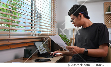 Young asian nab stock trader checking and analyzing financial graph on tablet computer. Young asian nab stock trader checking and analyzing financial graph on tablet computer. 84683299