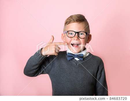kid point on his missing teeth. School boy with one missing tooth looking happy. Child with milk teeth waiting for present. Close up portrait of pupil with open mouth without milk tooth kid point on his missing teeth. School boy with one missing tooth looking happy. Child with milk teeth waiting for present. Close up portrait of pupil with open mouth without milk tooth 84683720