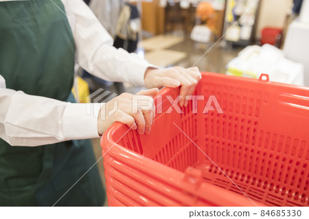 女員工在超市搬運已清理的購物車 84685330