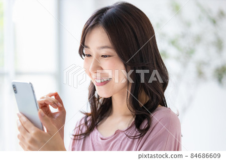 穿著便裝並操作智能手機的女性 84686609