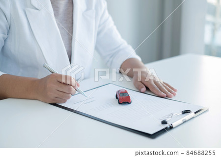 The hands of the real estate agent draw up an agreement, contractual documents on car loans 84688255