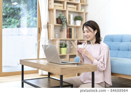 A woman making a video call on a computer A woman making a video call on a computer 84688984